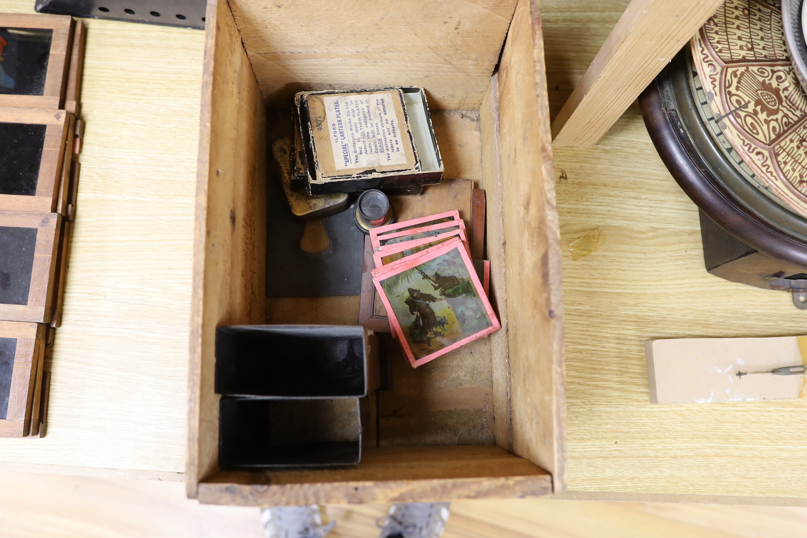 A magic lantern and a quantity of glass slides, including eleven novelty moving painted slides